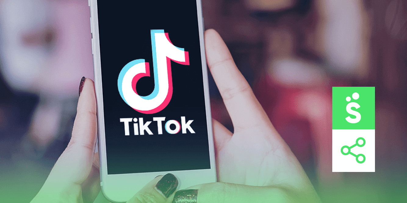 Pessoa com um celular com a tela do TikTok Ads